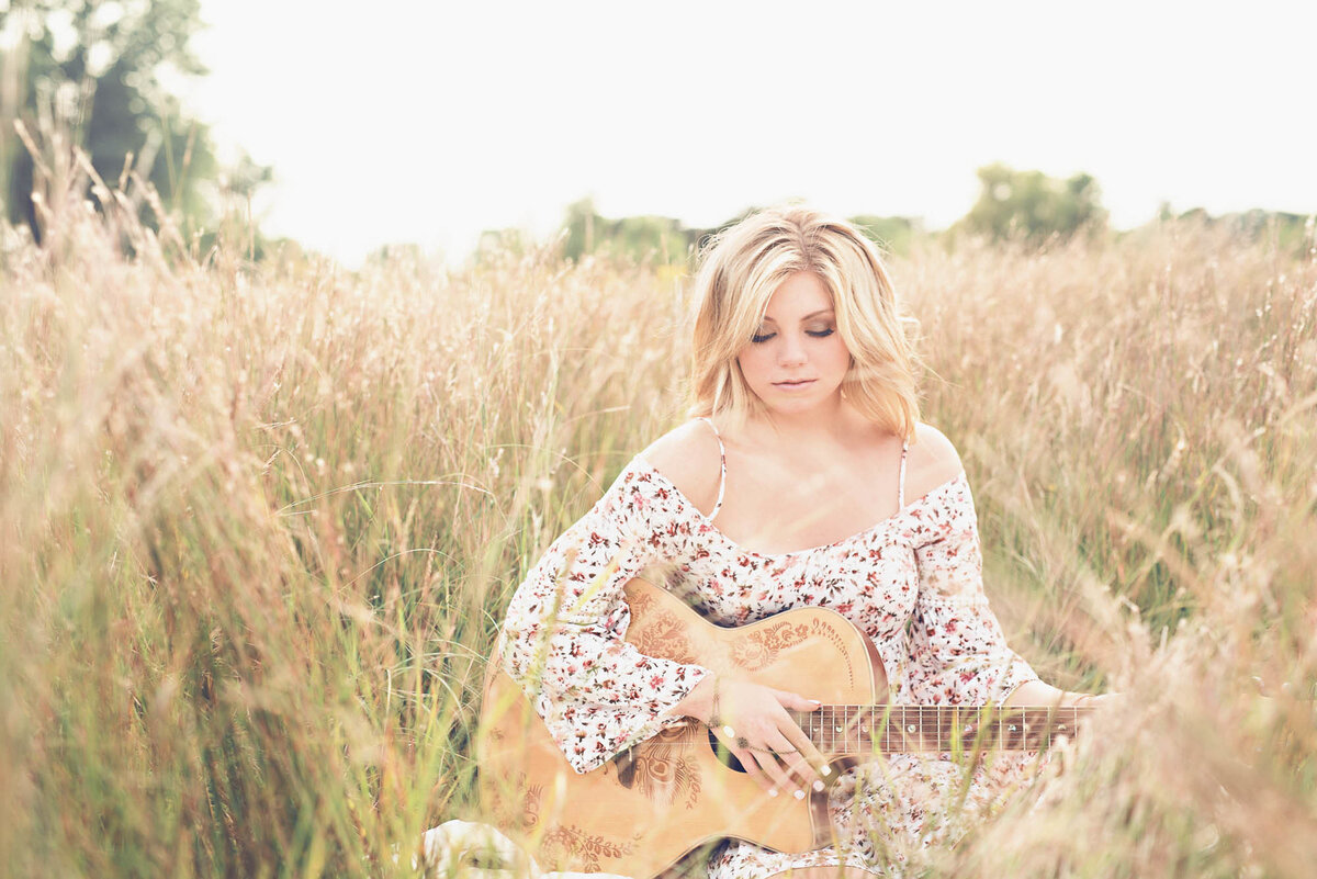 Senior picture with guitar in field