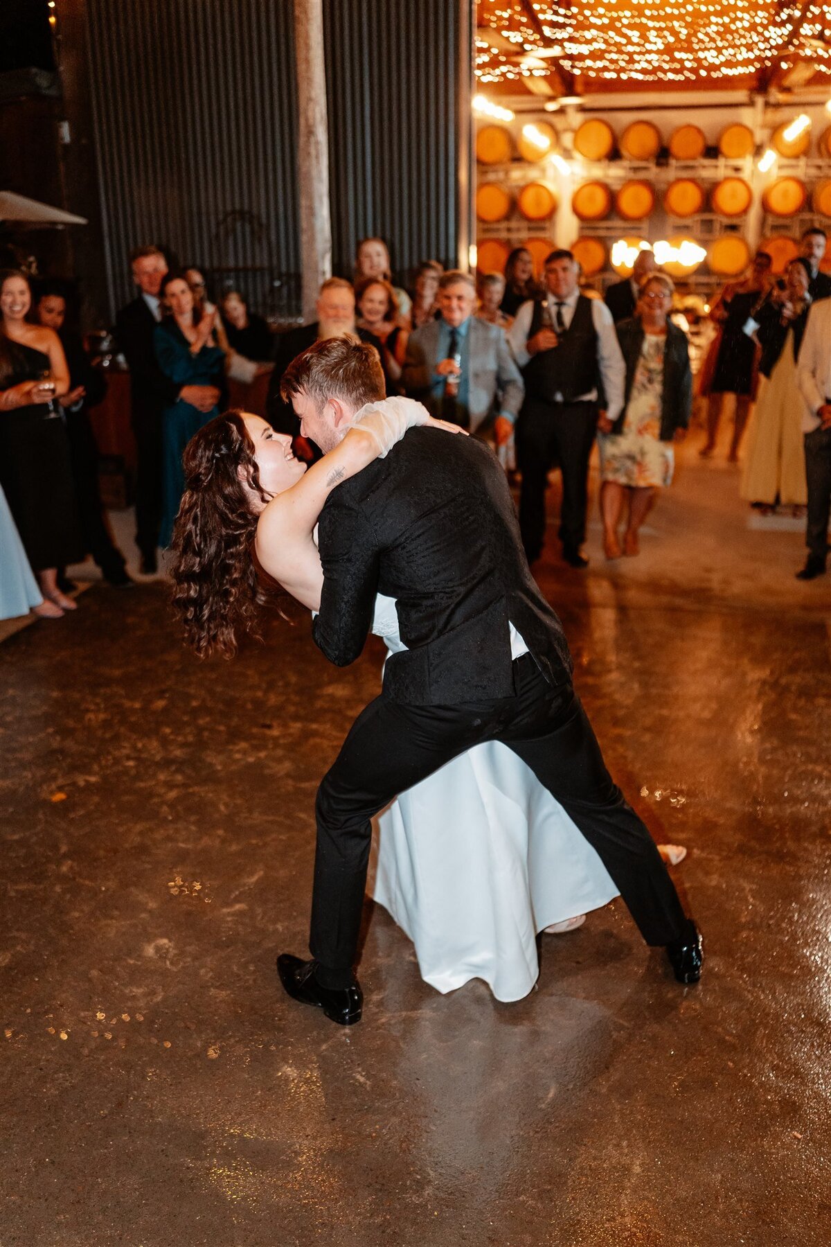 A heartwarming moment captured: a couple swaying together on the dance floor at their wedding reception, enveloped in love and joy.