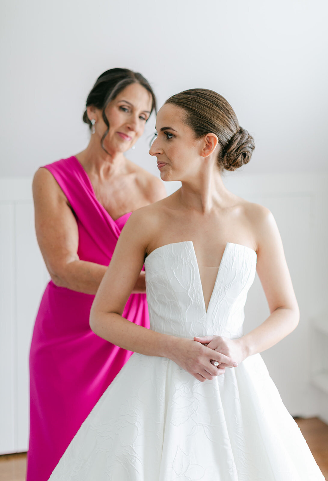 bride-with-her-mom-putting-on-wedding-dress