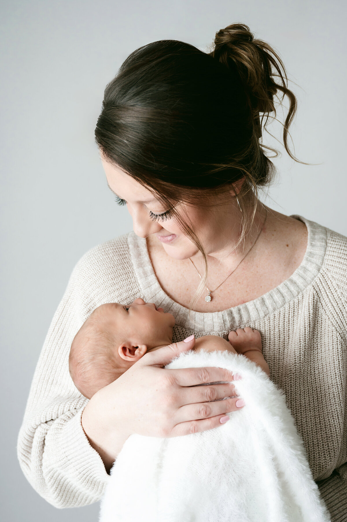 A beautiful mother and newborn baby portrait captured in Pittsburgh, PA. This tender moment features a mother lovingly holding her baby, creating a warm and intimate image that reflects the deep connection between mother and child.