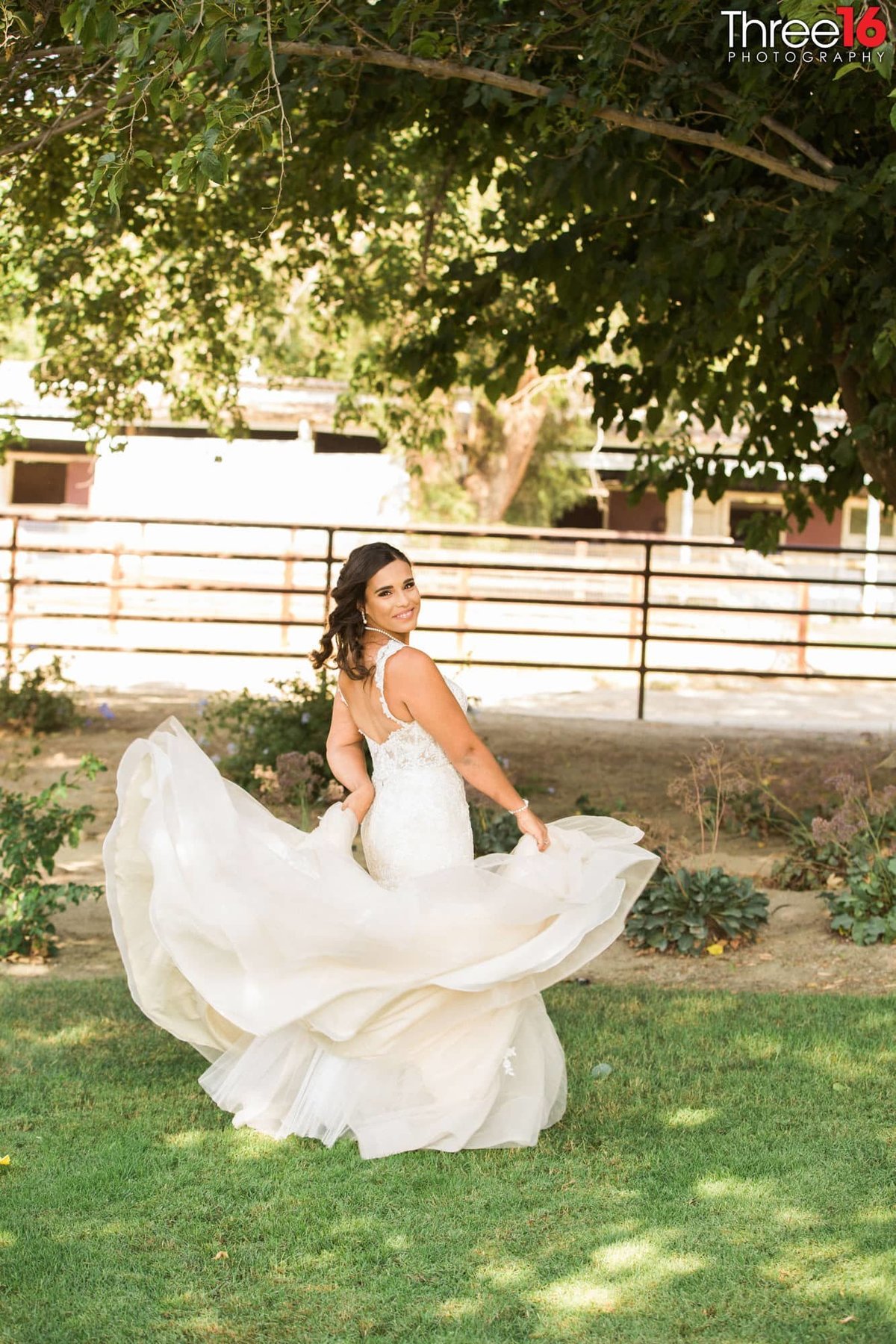 Bride twirls her fanned out wedding dress during a photo session