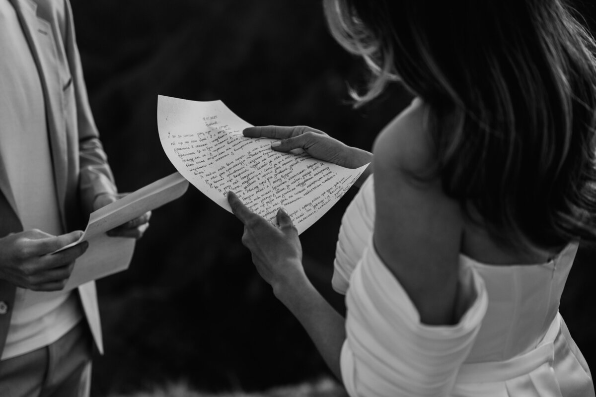 romatic couple reading vow in mountain elopement in Dolomites