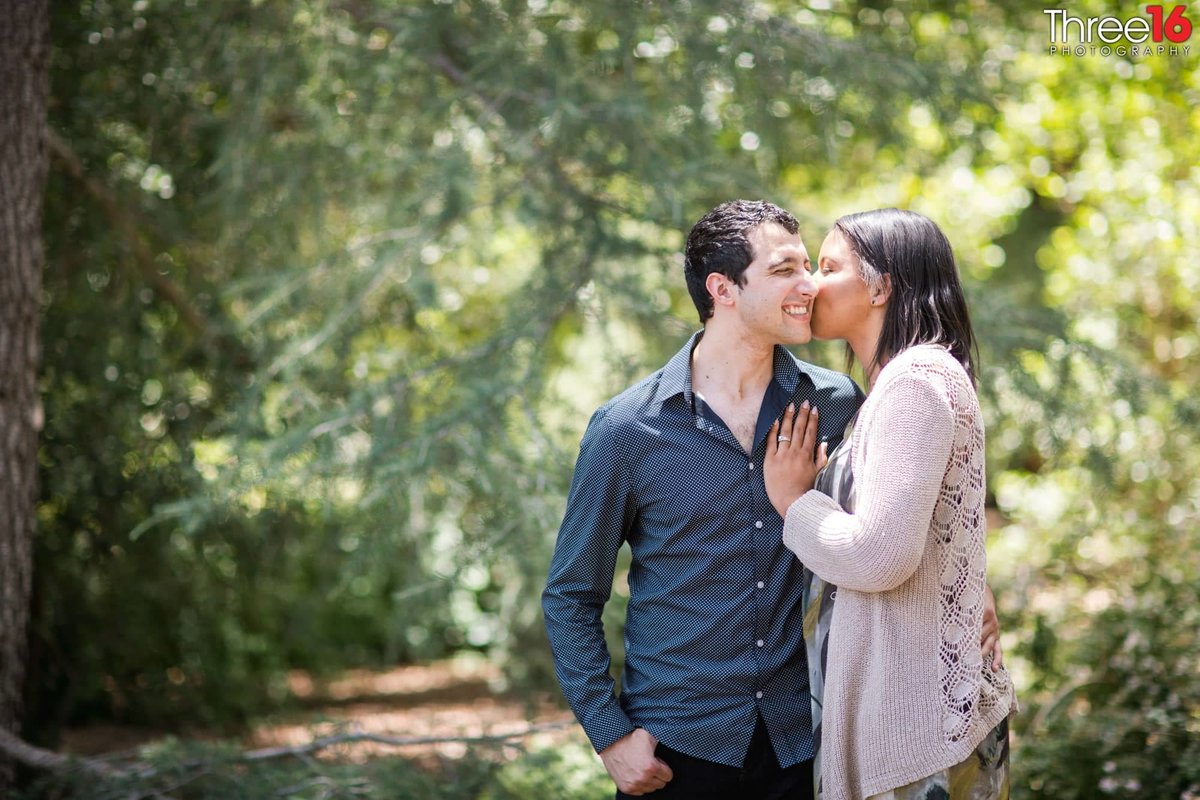 Engaged couple share a kiss