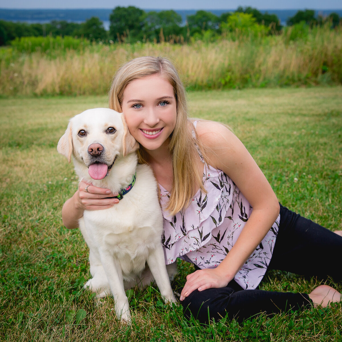 Cute senior portrait with girl and her dog with Seneca Lake in the background taken by You-nique Photography