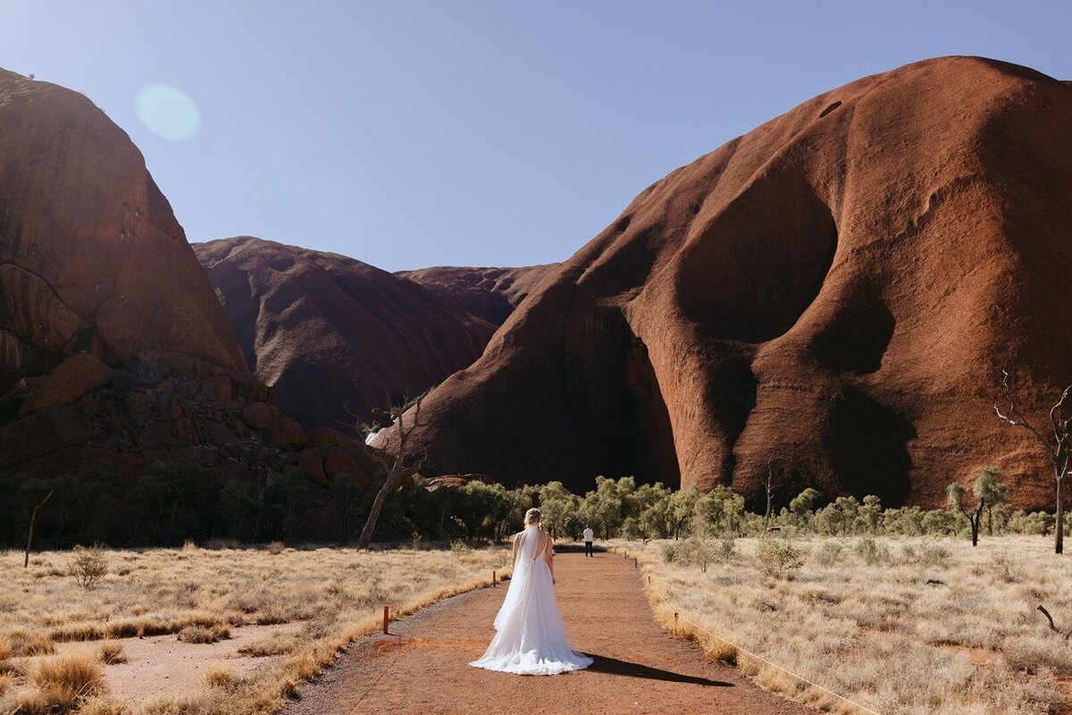 Bride standing below Uluru