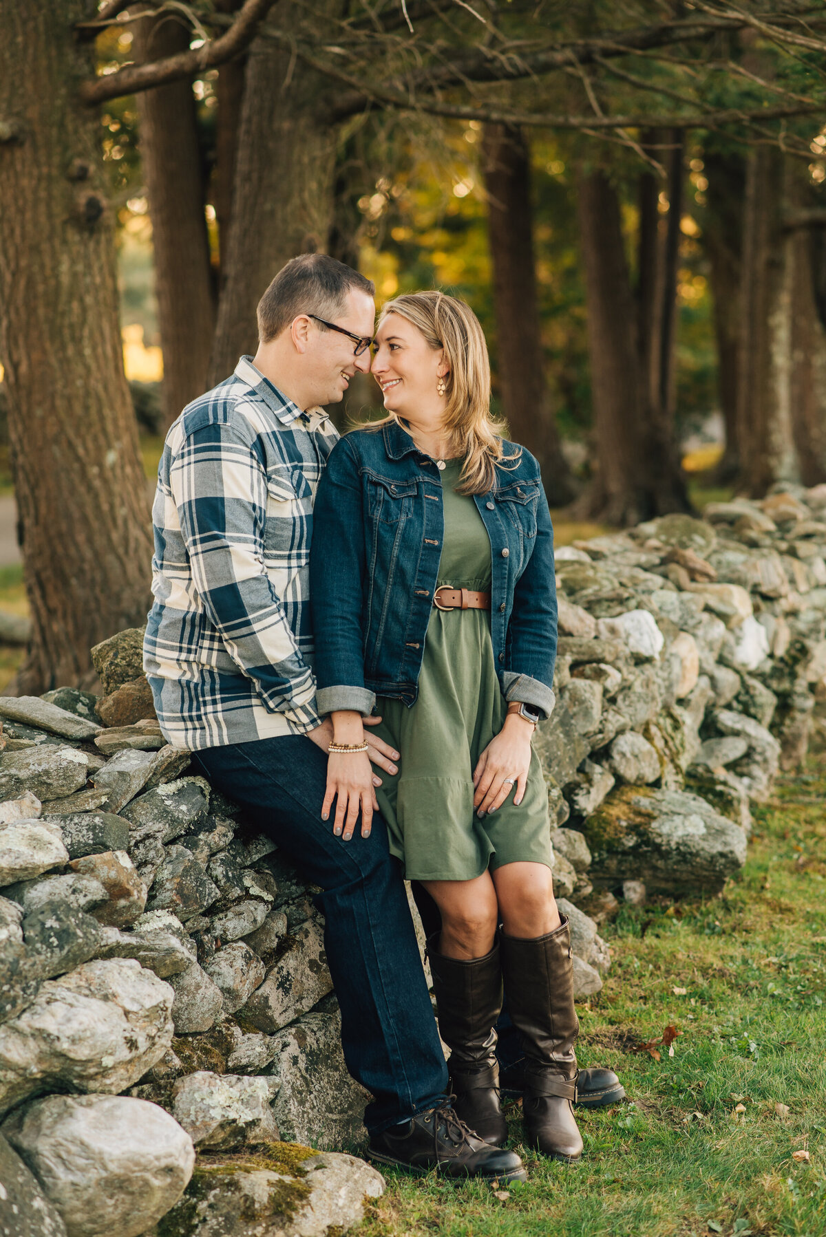 Parents smiling at each other, leaning against stone wall