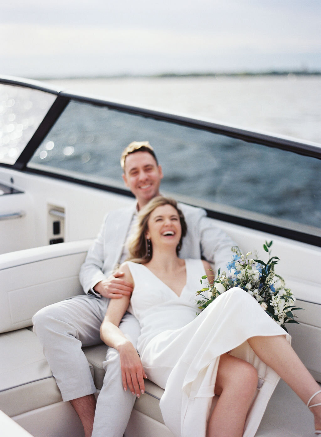 couple cuddled up in boat laughing on the water in new york city