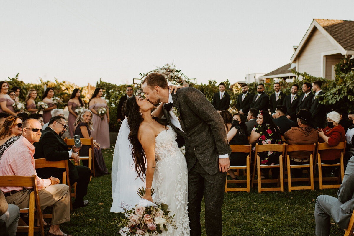 couple kissing at wedding venue in Sacramento at Scribner Bend Vineyards Winery.