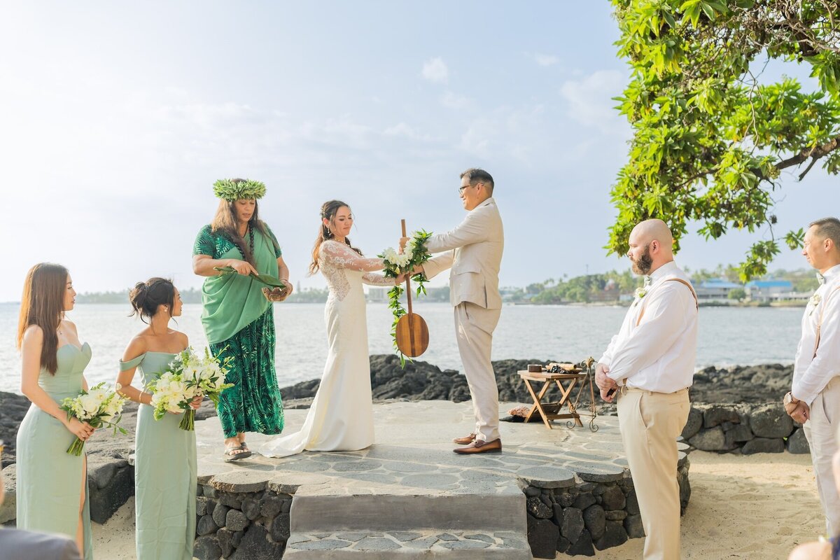Big Island Wedding Photography of bride and groom holding canoe paddle