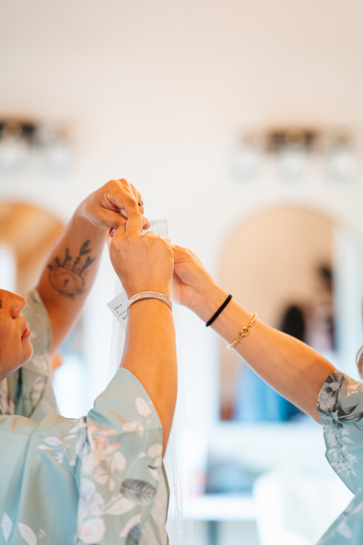 Bride putting on earrings in soft window light before her New England wedding