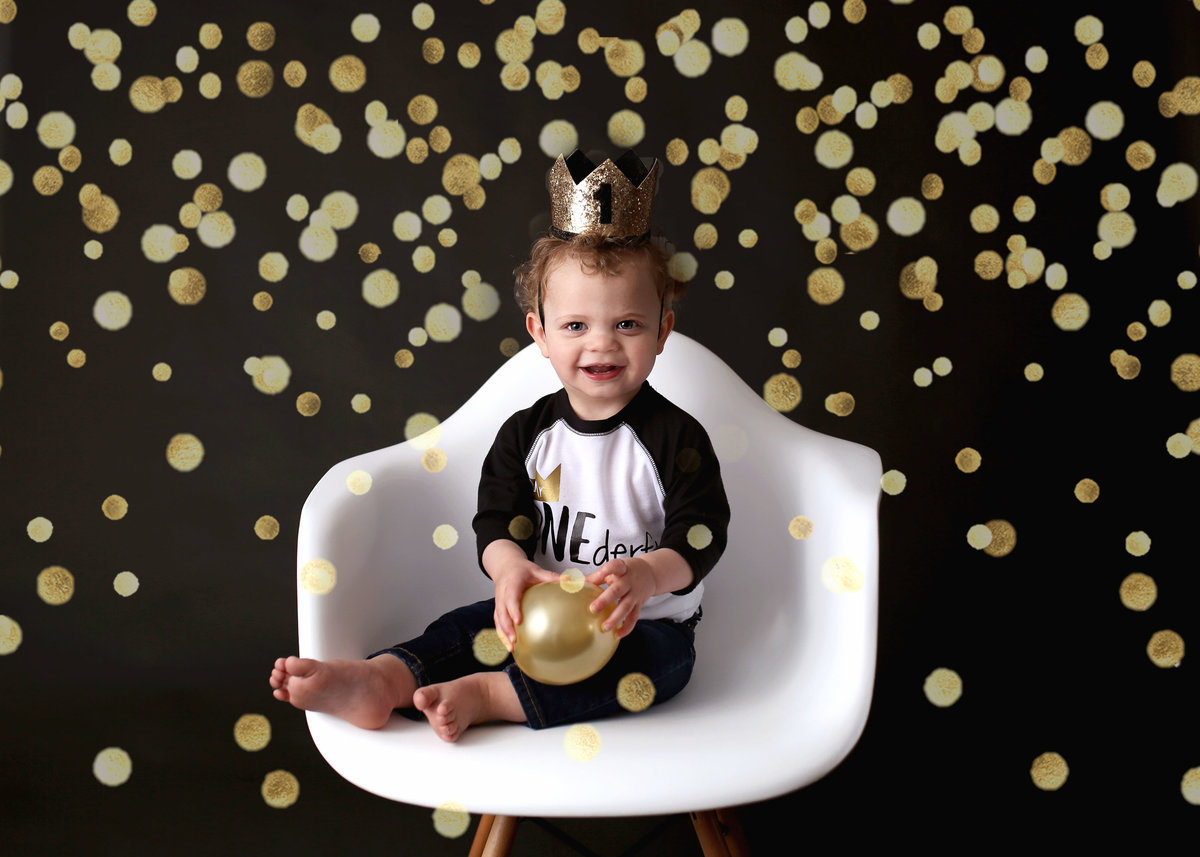 baby boy celebrating one year birthday with metallic gold accents