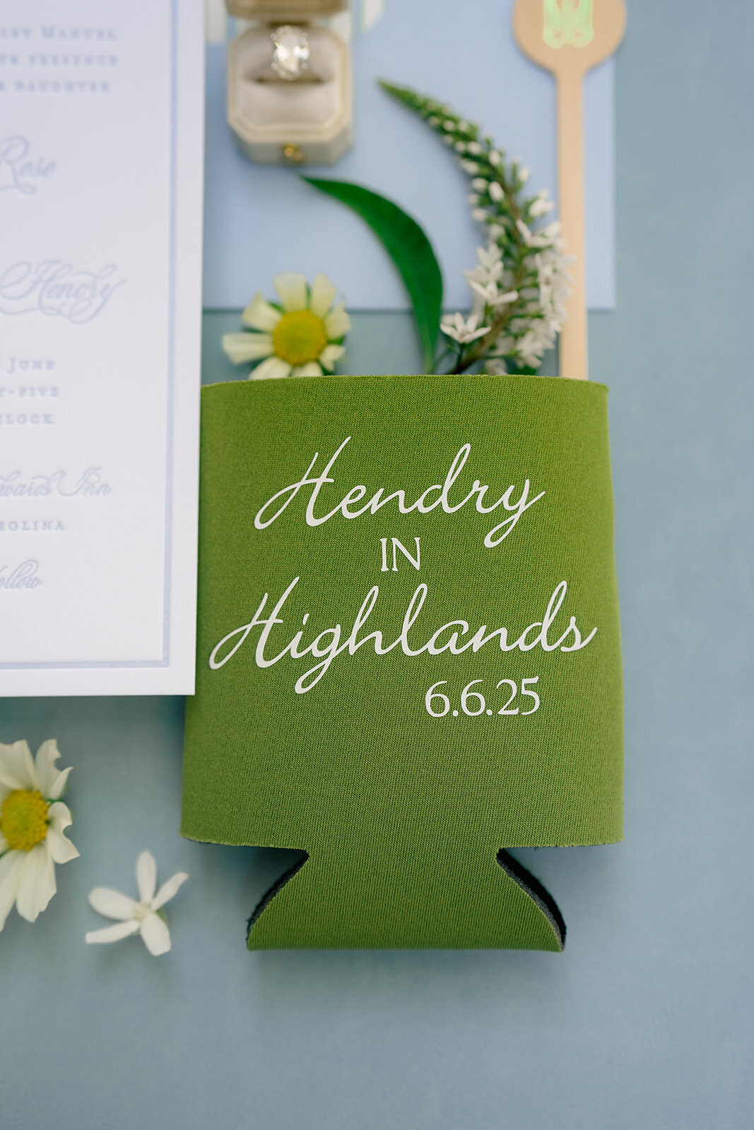 Green custom drink koozie with wedding branding and date, styled with stationery and florals for a wedding at Old Edwards Inn in Highlands, North Carolina.
