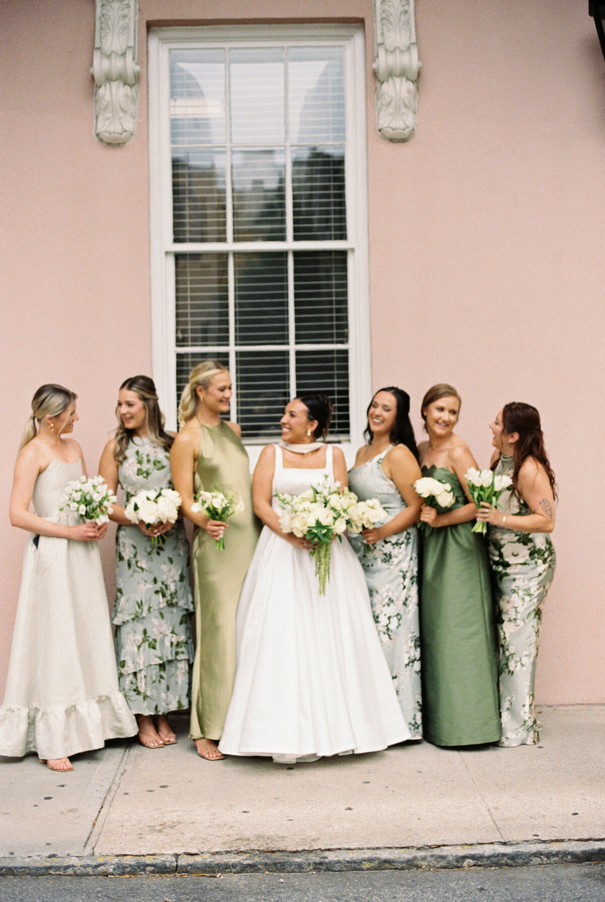 a gorgeous bridal party posing for a film photo in outside charleston sc