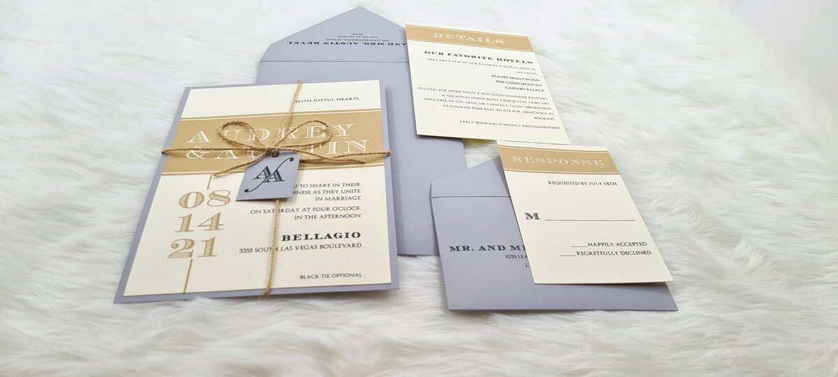 grey and mustard yellow layed invitation tied with twine with a monogrammed tag