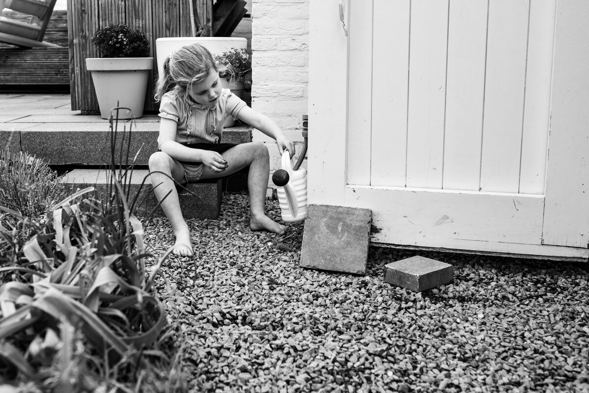 fotoshoot aan huis kind vult gieter in tuin