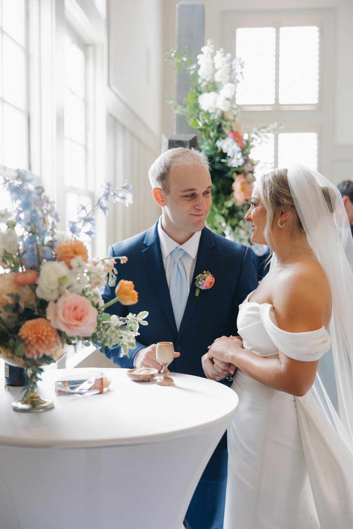 Bride and groom taking communion at The Chapel at the Waters