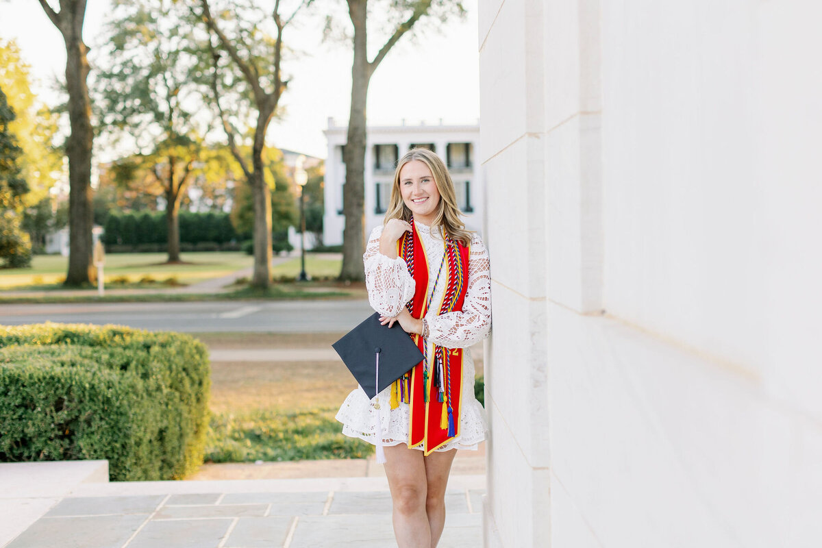 Alabama graduate smiling with cords and cap