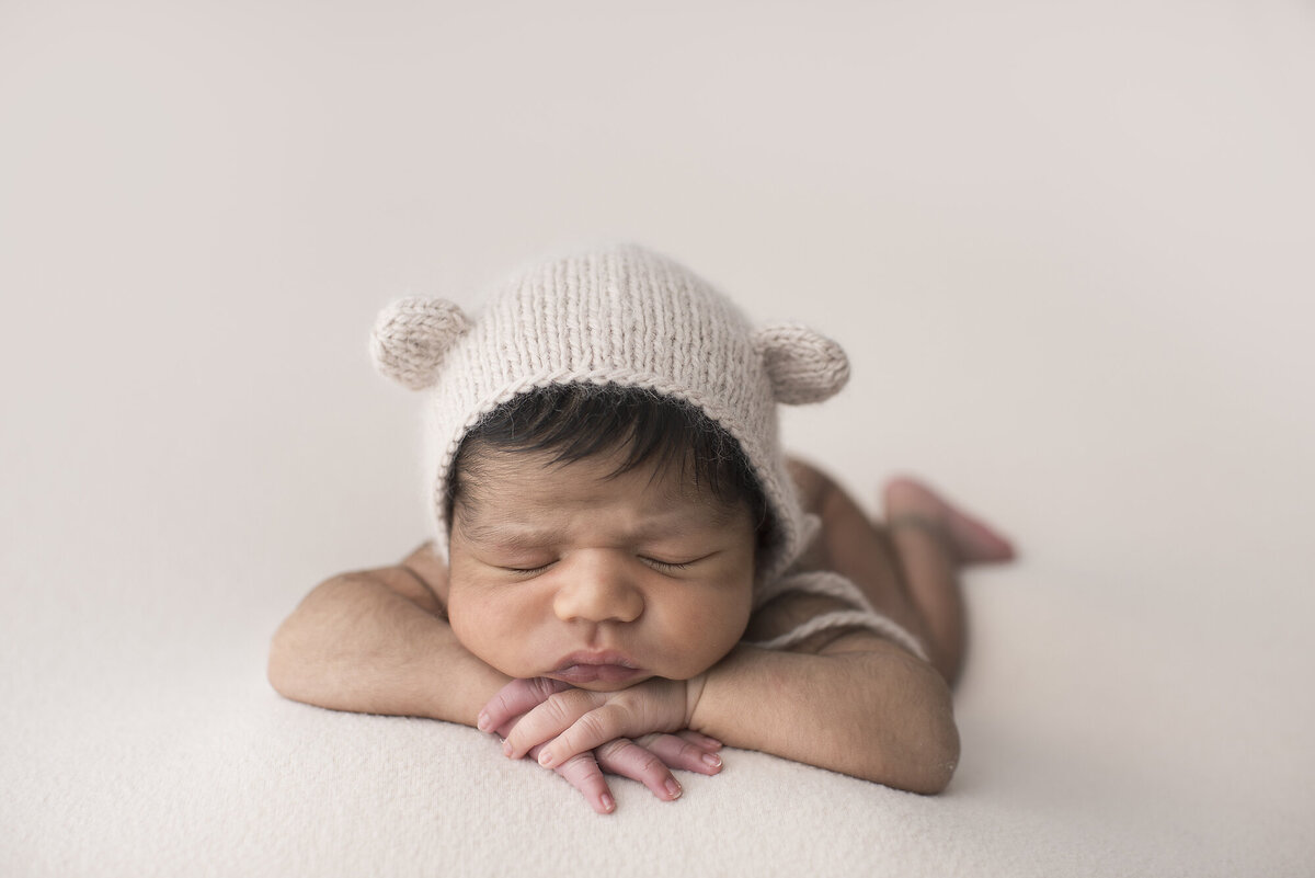 a photo session of a baby with a animal beenie