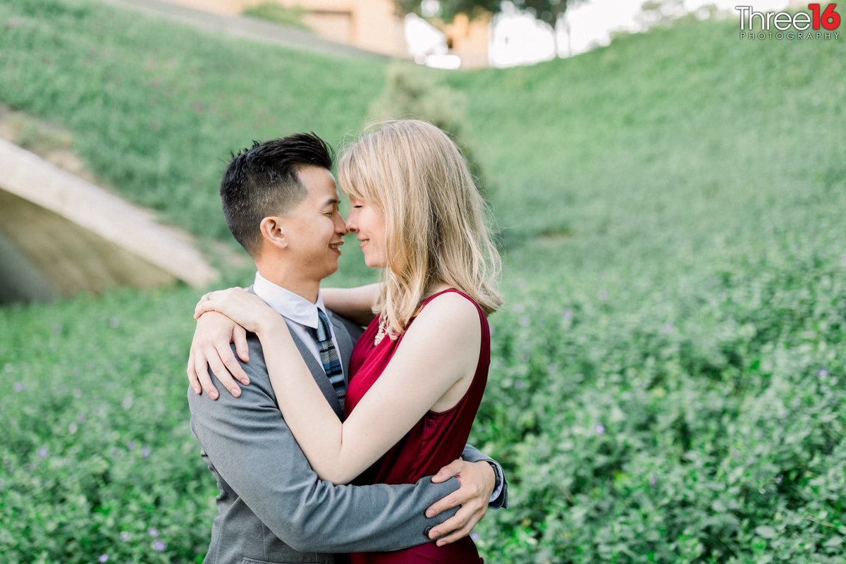 Engaged couple cuddle nose to nose during engagement photo session