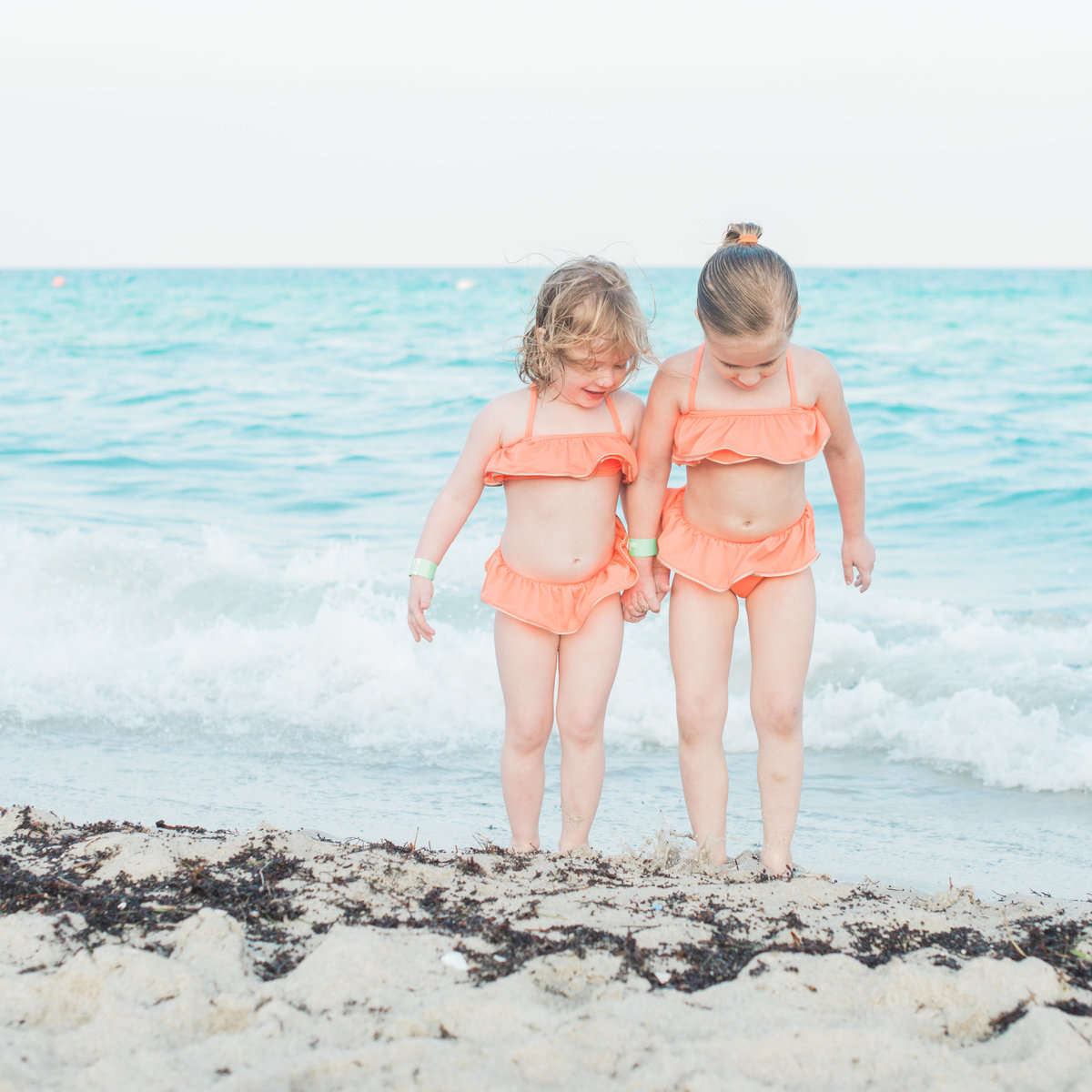 little girls in coral swimsuits on miami beach