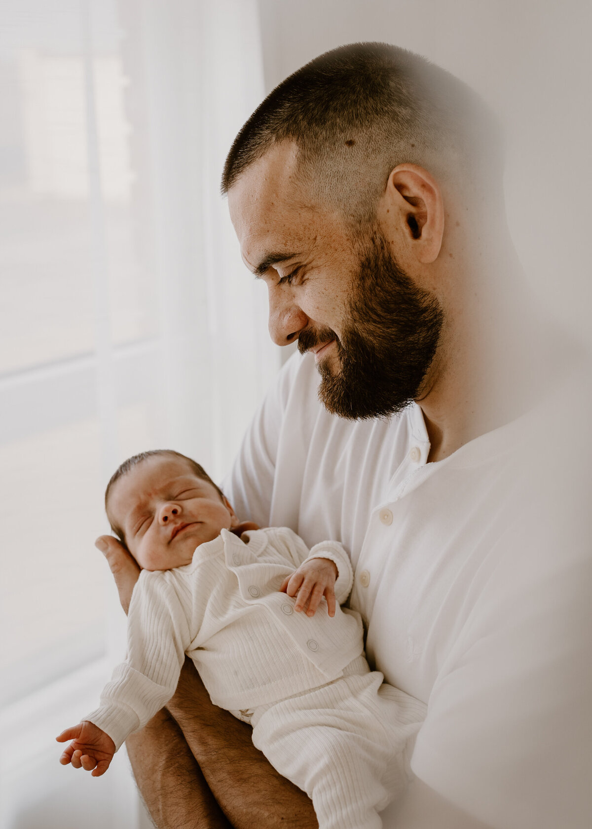 Dad holding newborn smiling