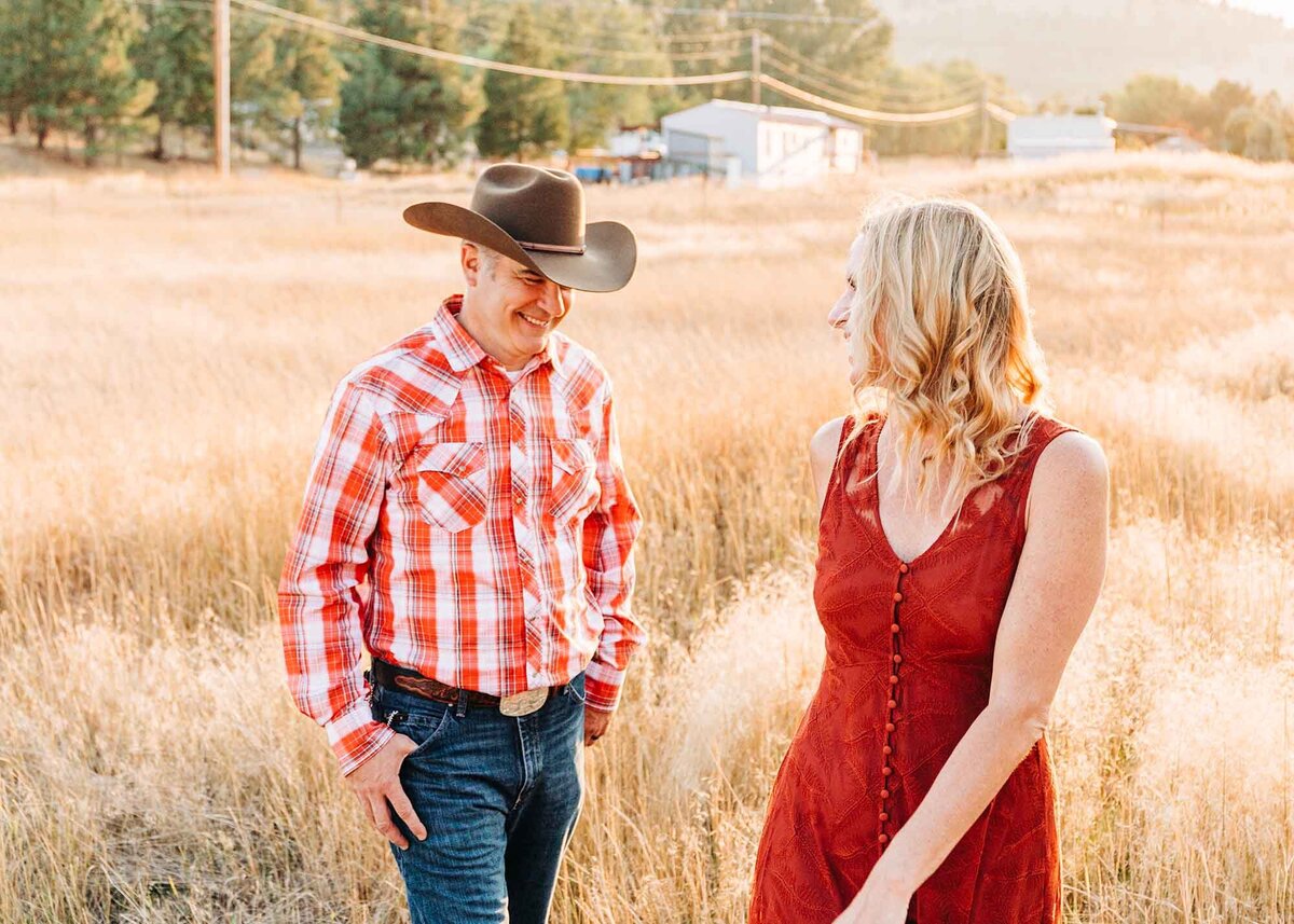 Montana engaged couple walking in field at Traveler's Rest State Park, Lolo