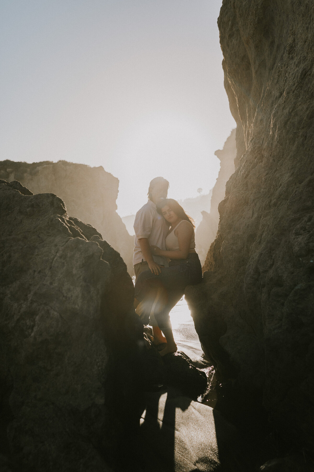 Couple silhouetted against a sunlit rock wall, romantic Indiana engagement.