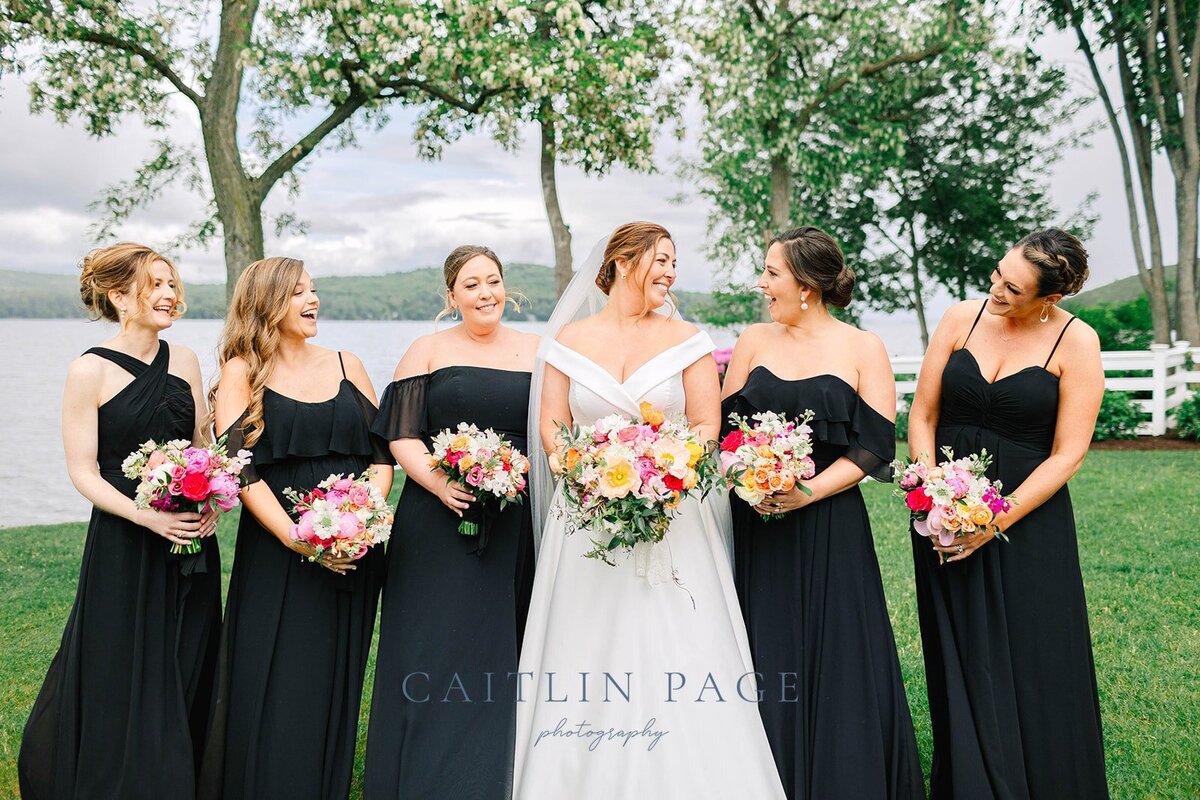Black bridesmaids dresses pop with the brightly colored flowers.