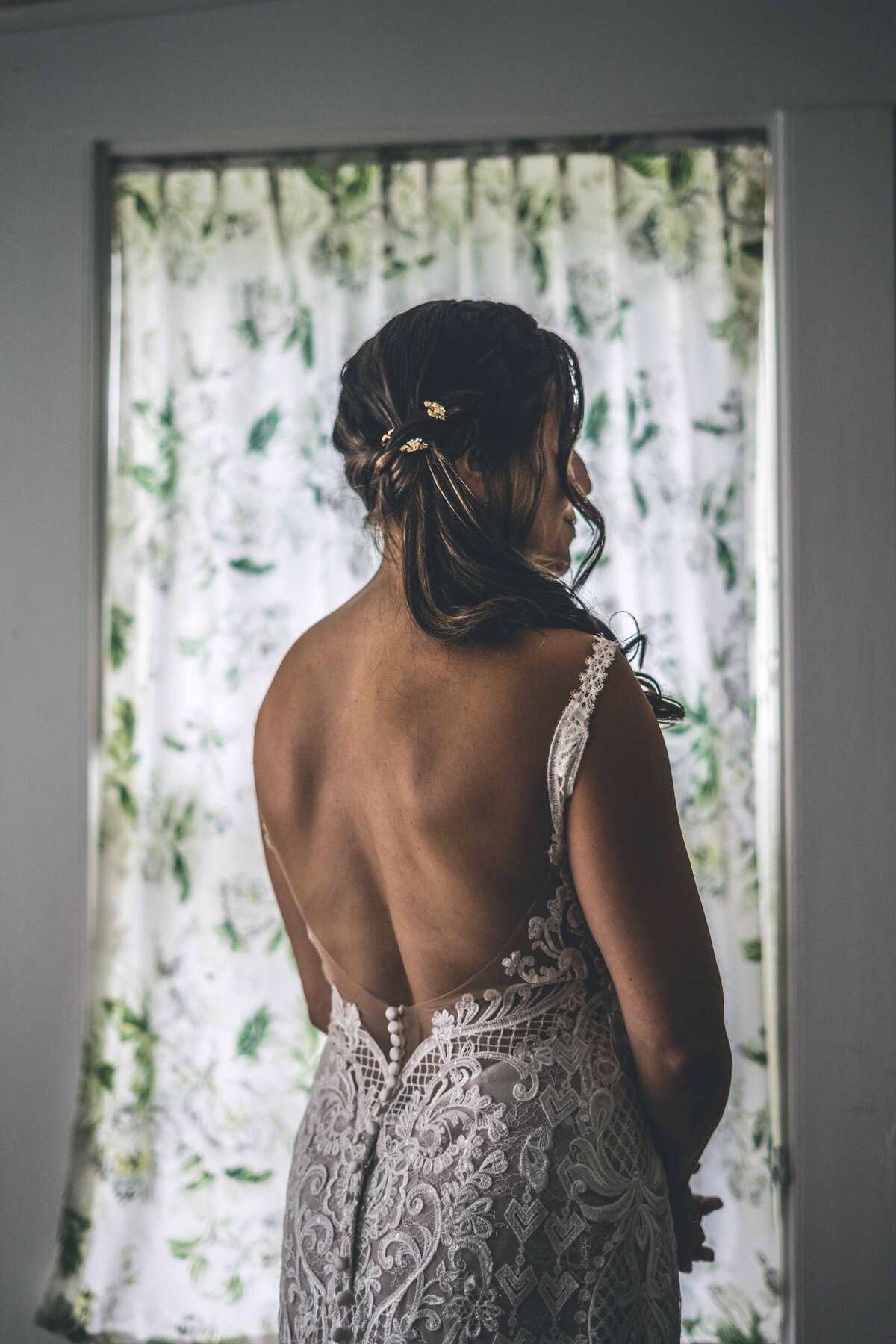 a bride in front of a window with her back turned