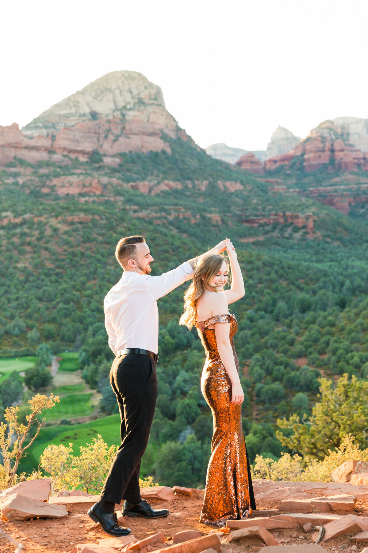 man twirling his fiance in Sedona engagement session