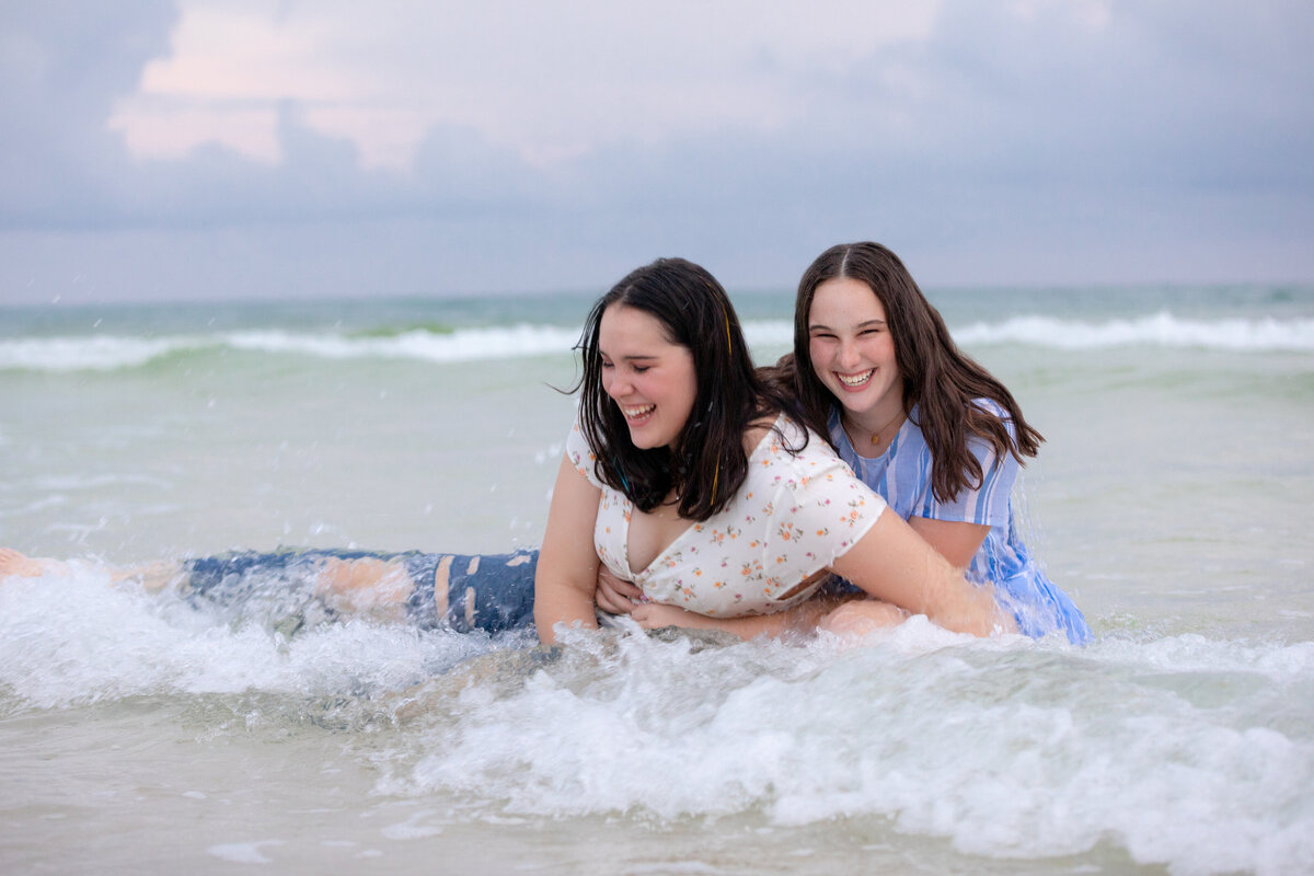 Two girls paying together in the waves