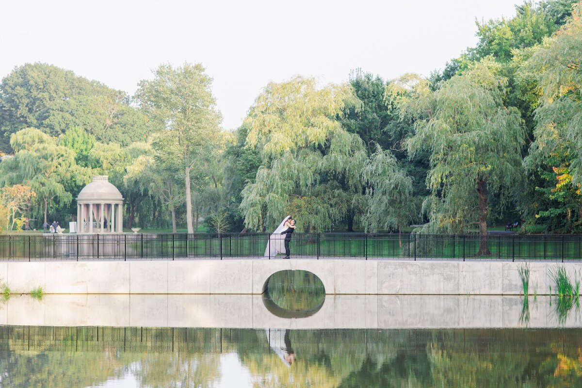 Groom picking up and kissing his bride at Larz Anderson Park