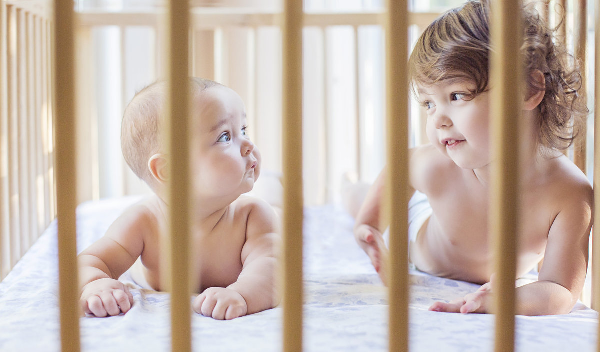 charlotte documentary photographer jamie lucido creates a beautiful image of siblings playing in their crib