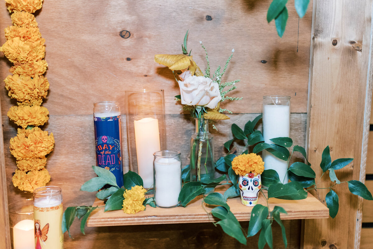 Candles and greenery displayed on a wooden wedding reception backdrop