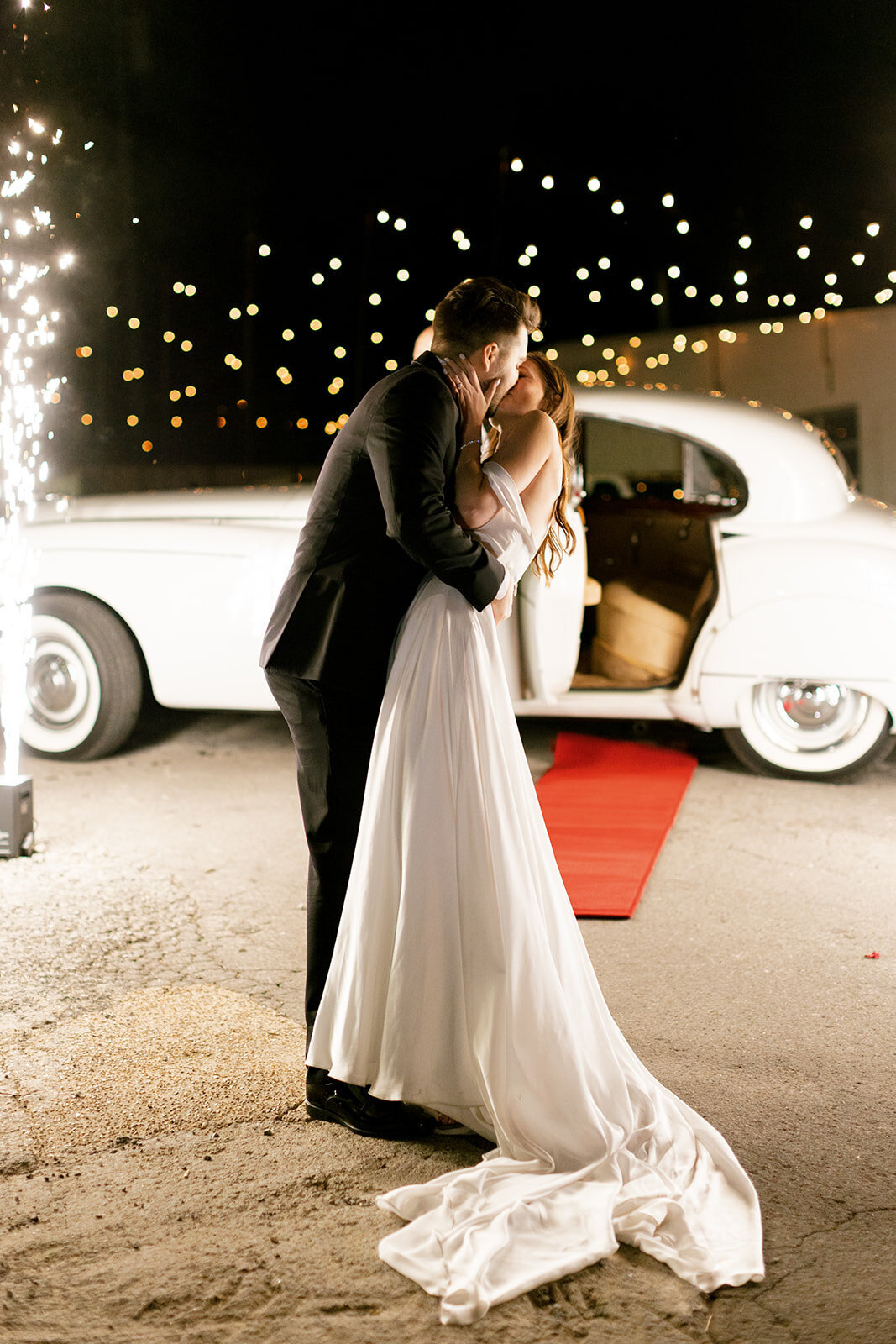 bride-and-groom-kissing-with-getaway-car