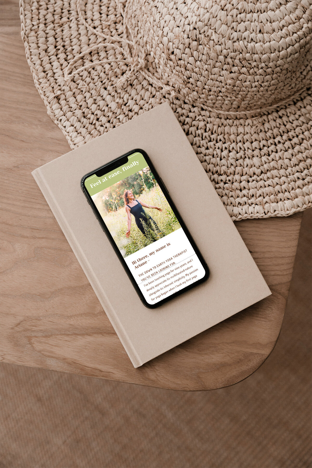Iphone laying on book open to website for Yoga Instructor