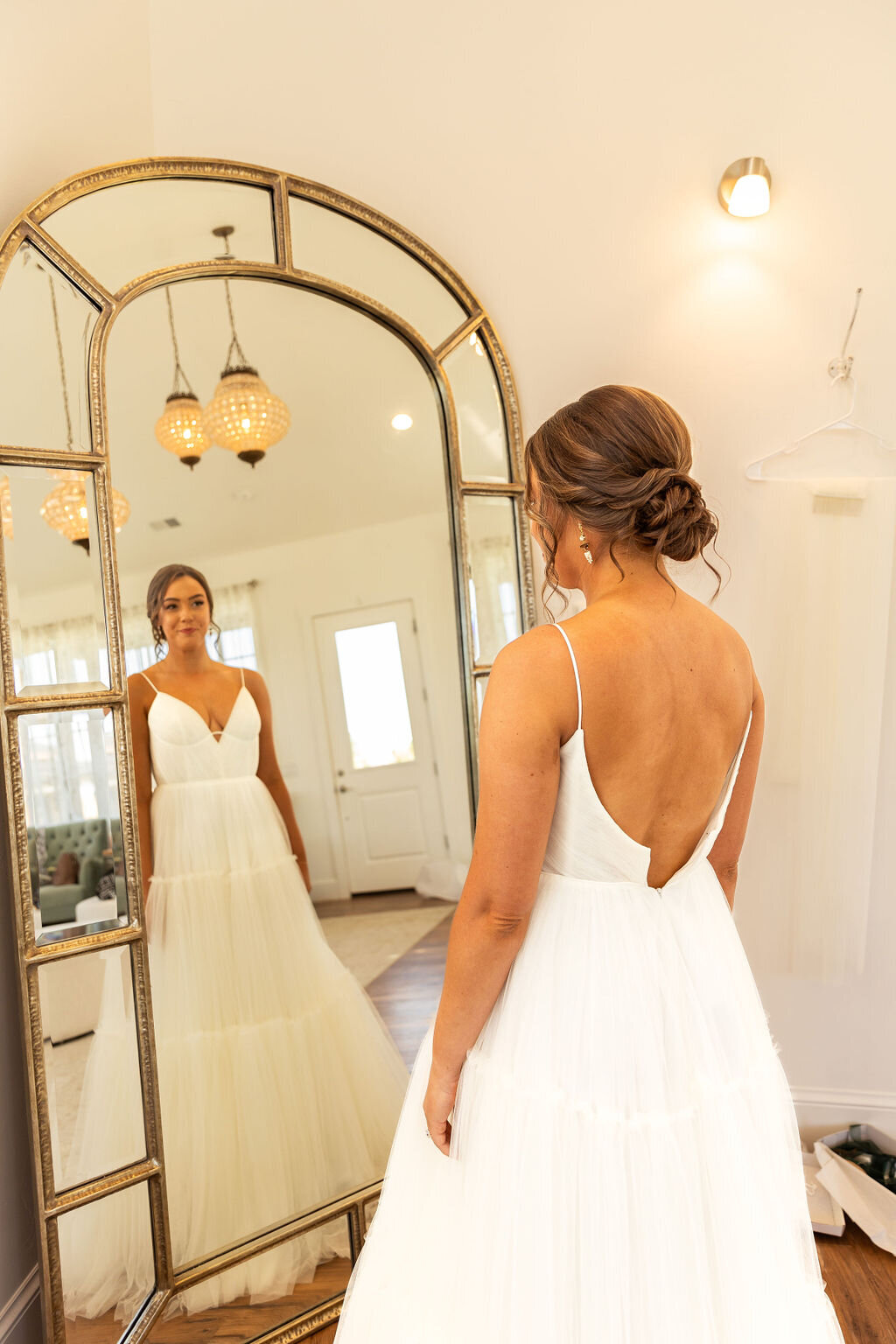 Bride sees her final look in the mirror on her wedding day.