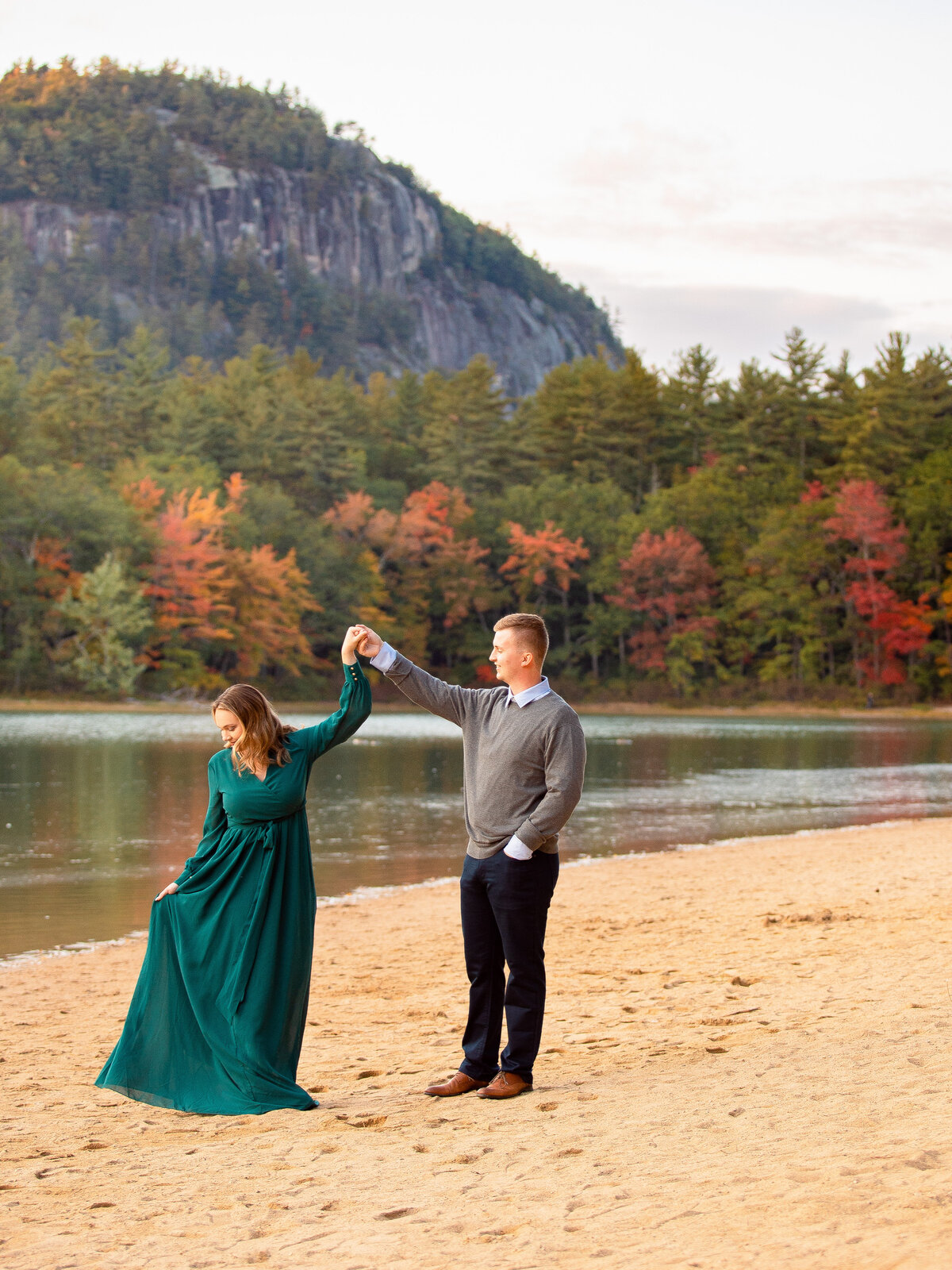 Engaged couple twirls at Echo Lake in Conway, NH.