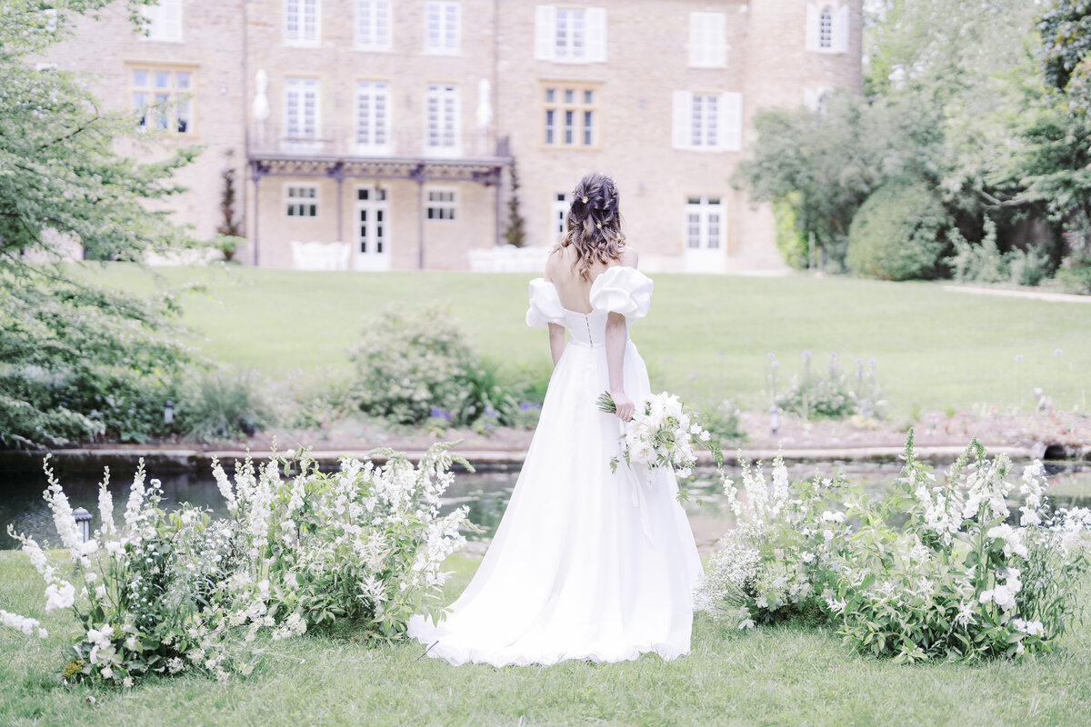 mariee-entouree-de-compositions-florales-au-sol-fleurs-blanches