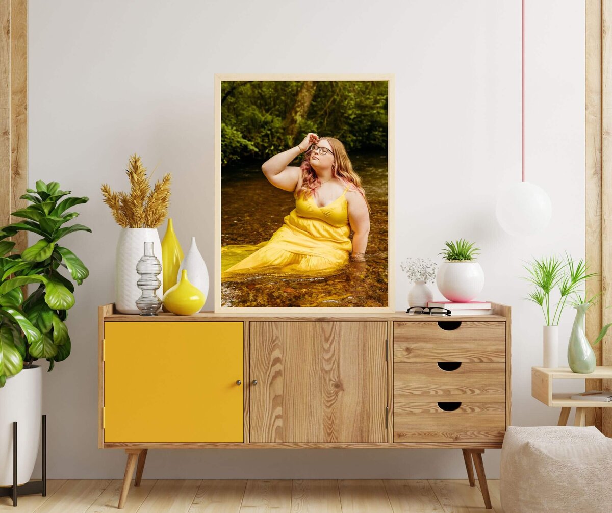 absolutely gorgeous entryway with a huge framed photo taken by Ashley Kalbus sitting on top of a wooden buffet with a yellow door