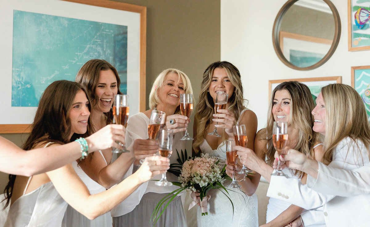 Bride Laura and her bridesmaids raising a toast before the wedding at Cheeca Lodge Resort, photographed by Claudia Amalia.