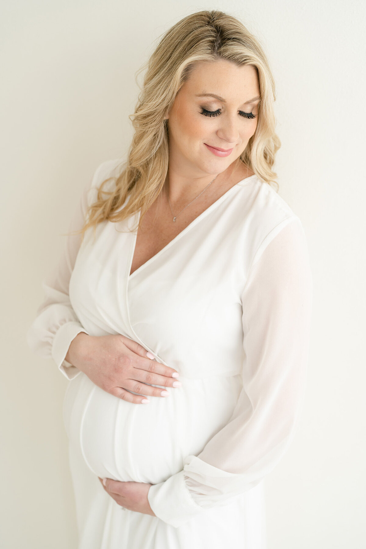 Pregnant Louisville KY mother wears white dress during maternity photo shoot at Julie Brock Photography