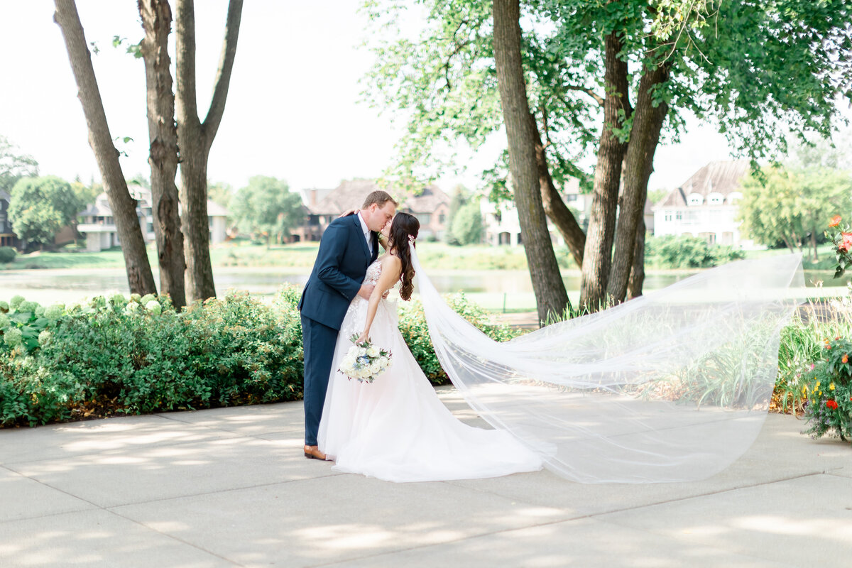 bride and groom kissing with veil flying in the wind by florida wedding photographers