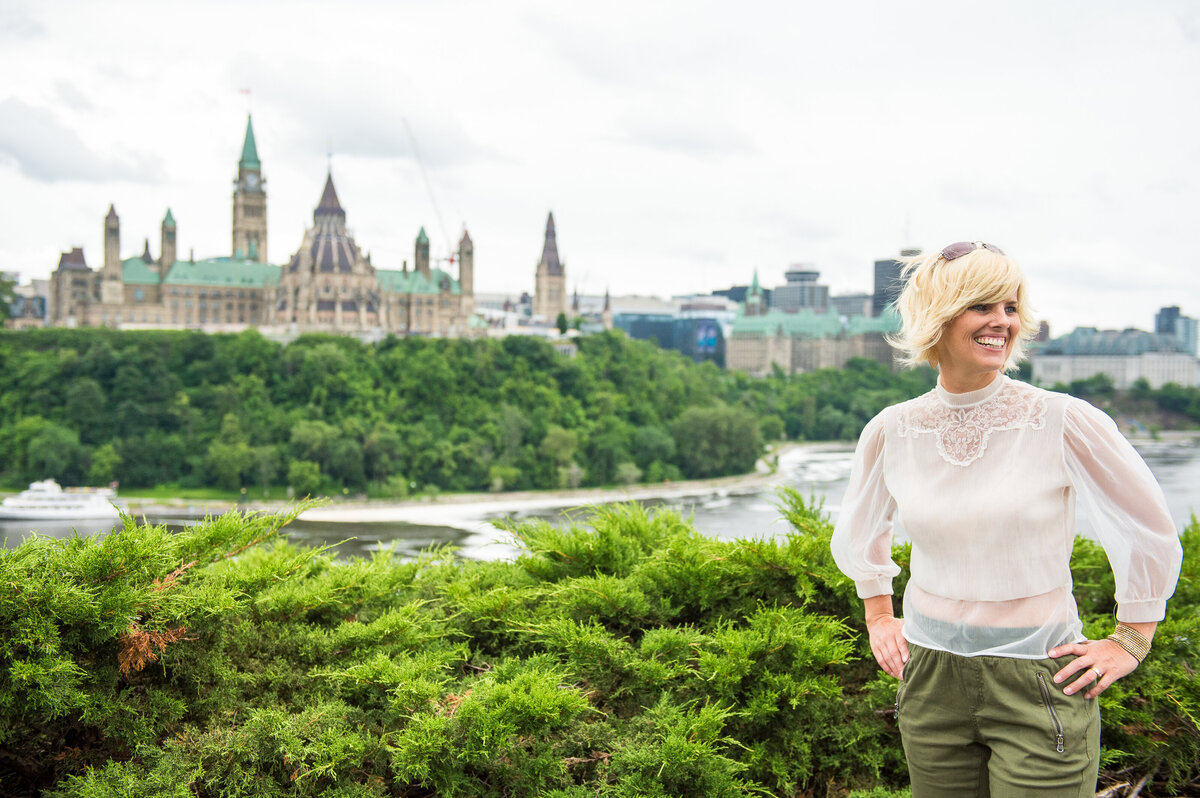 branding photo of a smiling solopreneur with Ottawa Parliament buildings in the background