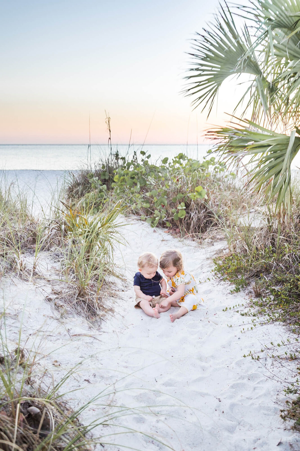 toddlers playing in the sand at the beach