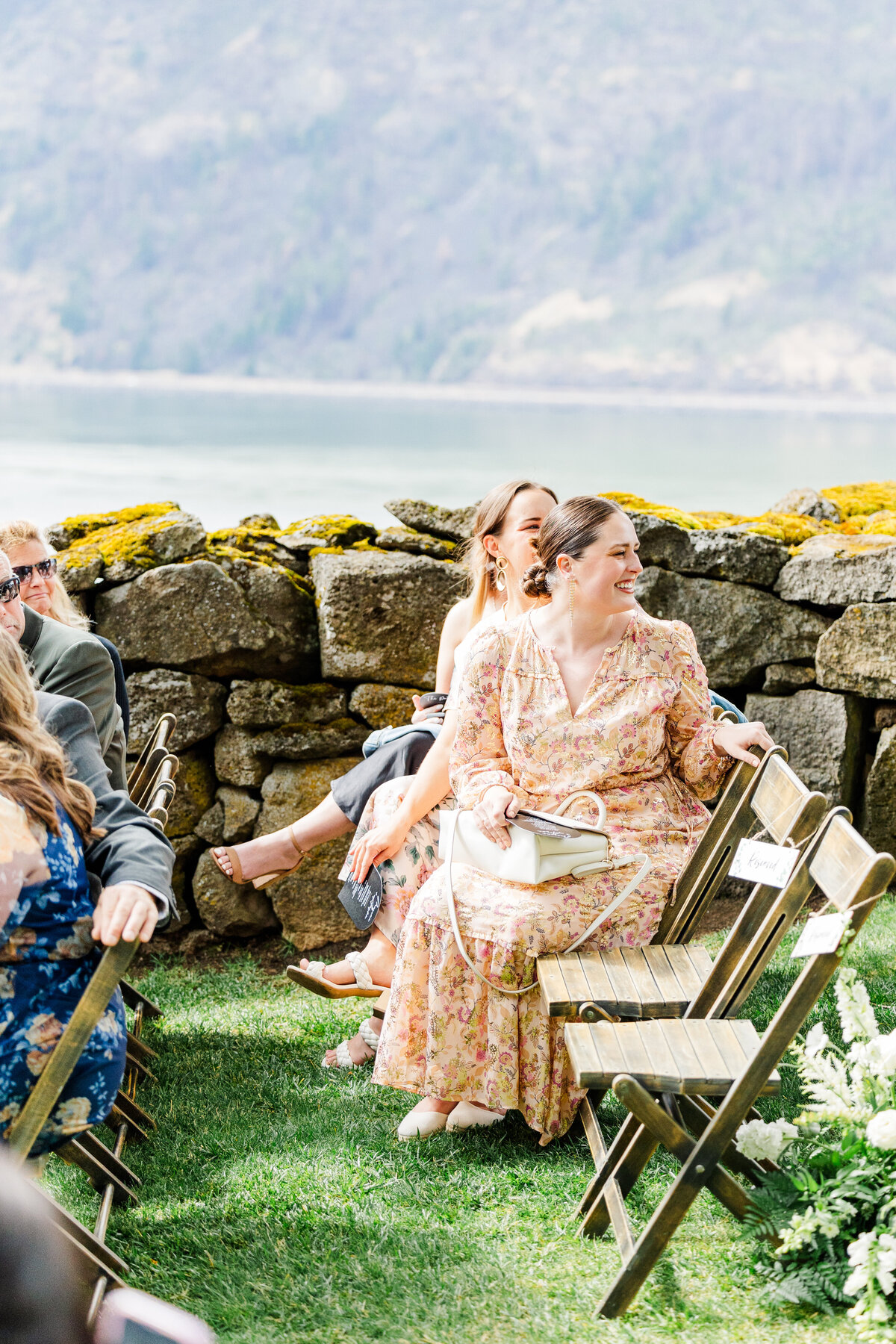 guests smiling as bride walks down aisle at griffin house