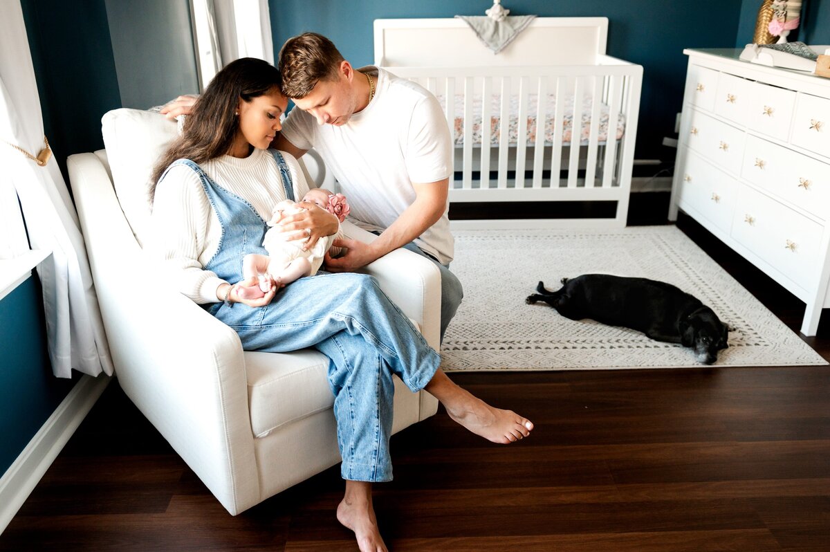 mom in rocking chair holding her baby with dad