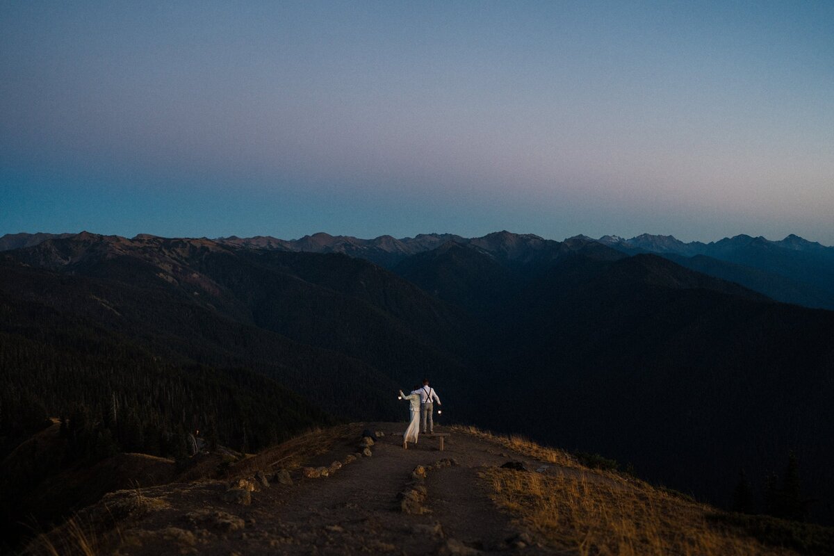 A Sunset Olympic National Park Elopement where a couple holds lanterns in the distance surrounded by mountains.