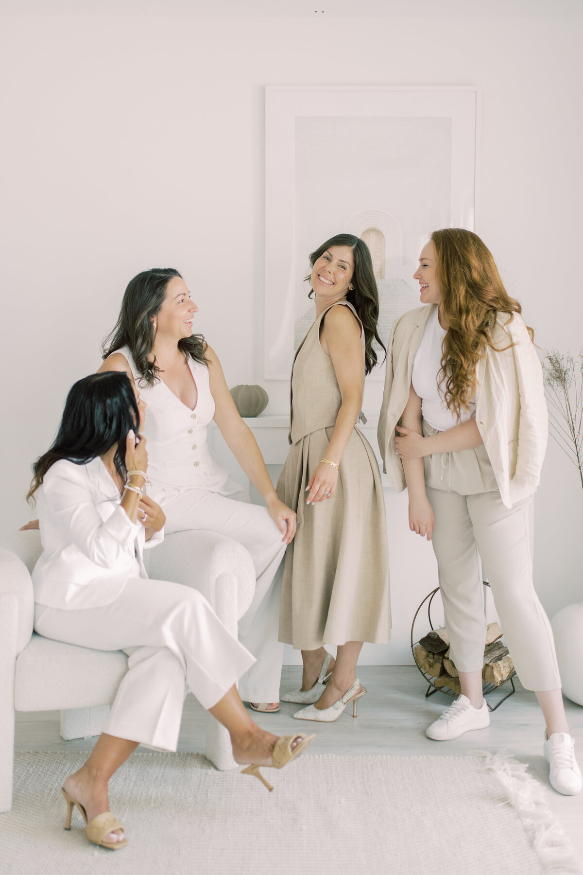 Candid moment of laughter between cosmetic team members in neutral tones—branding joy
