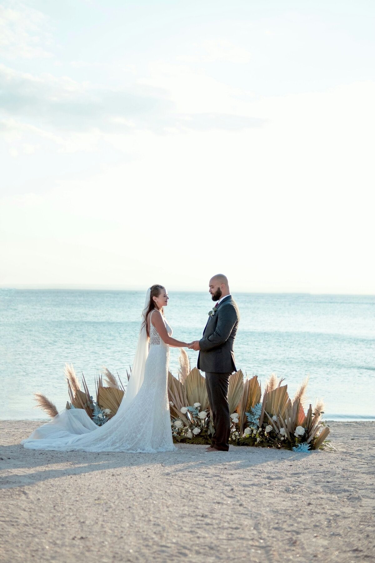 Boho barefoot bride and groom exchanging vows on Auckland beach